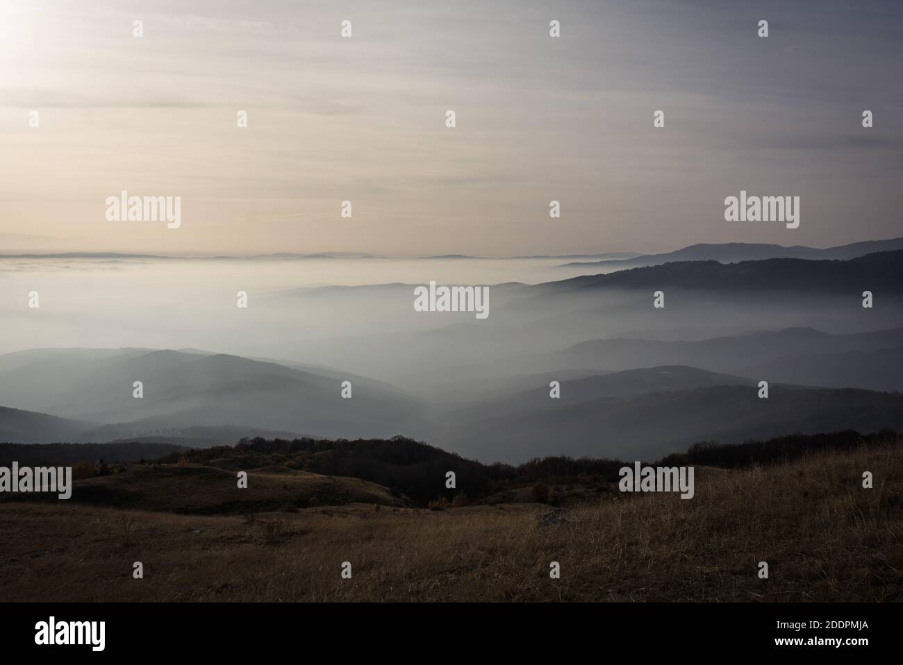 Low clouds over the mountains at sunset. Stock Photo