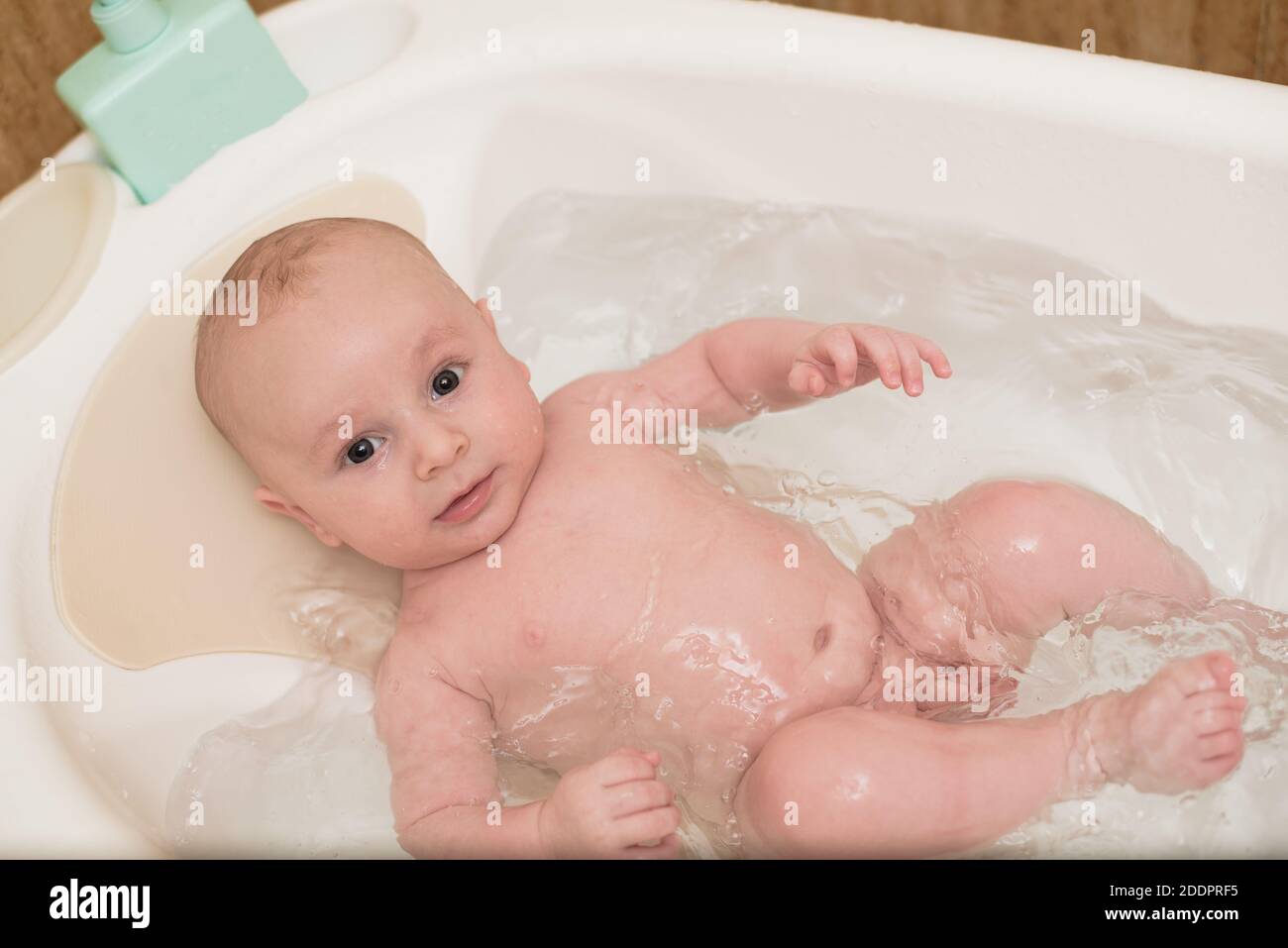 Cute baby having bath in white tub Stock Photo Alamy