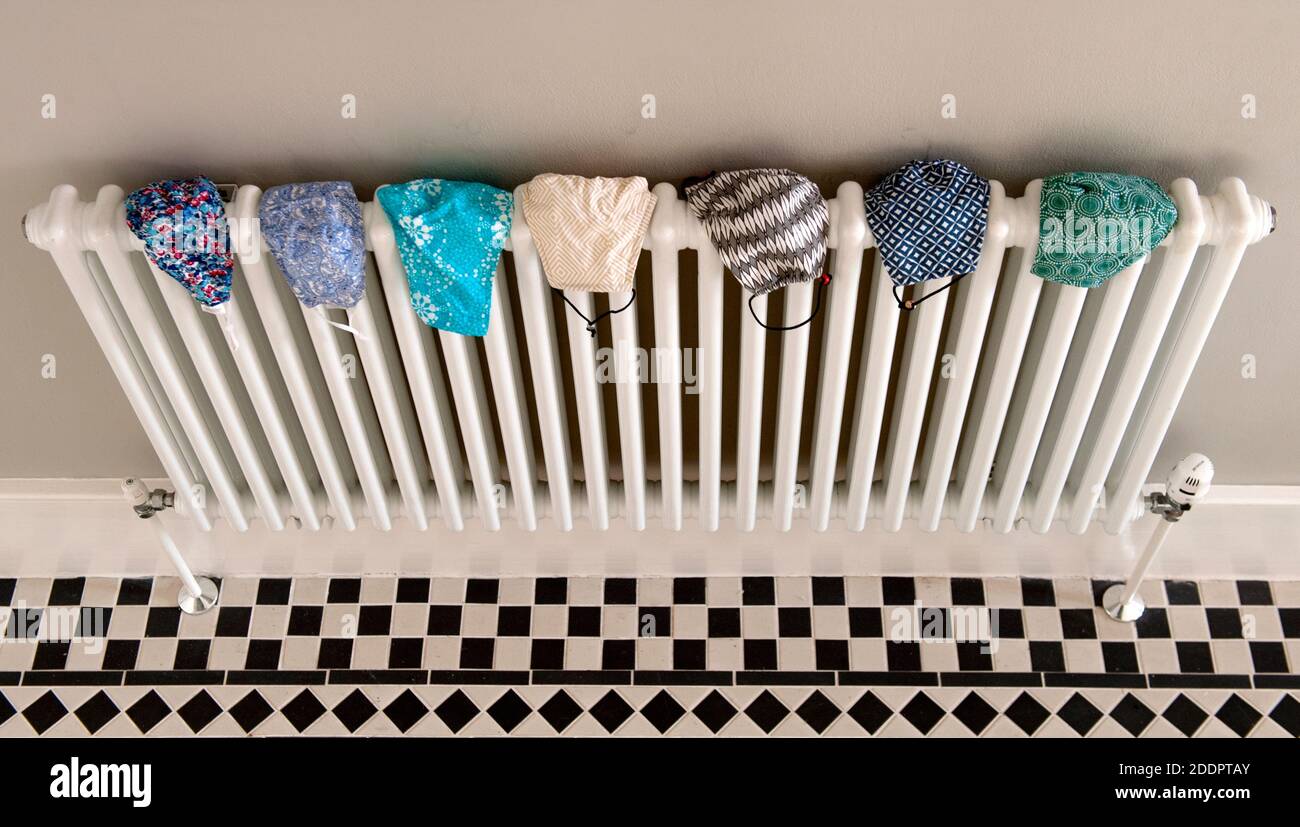 Face masks drying on radiator after being washed Stock Photo
