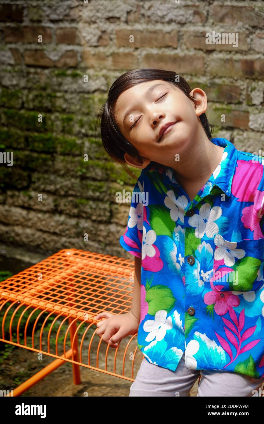 Happy Southeast Asian ethnicity little boy having fun sunbathing in the
