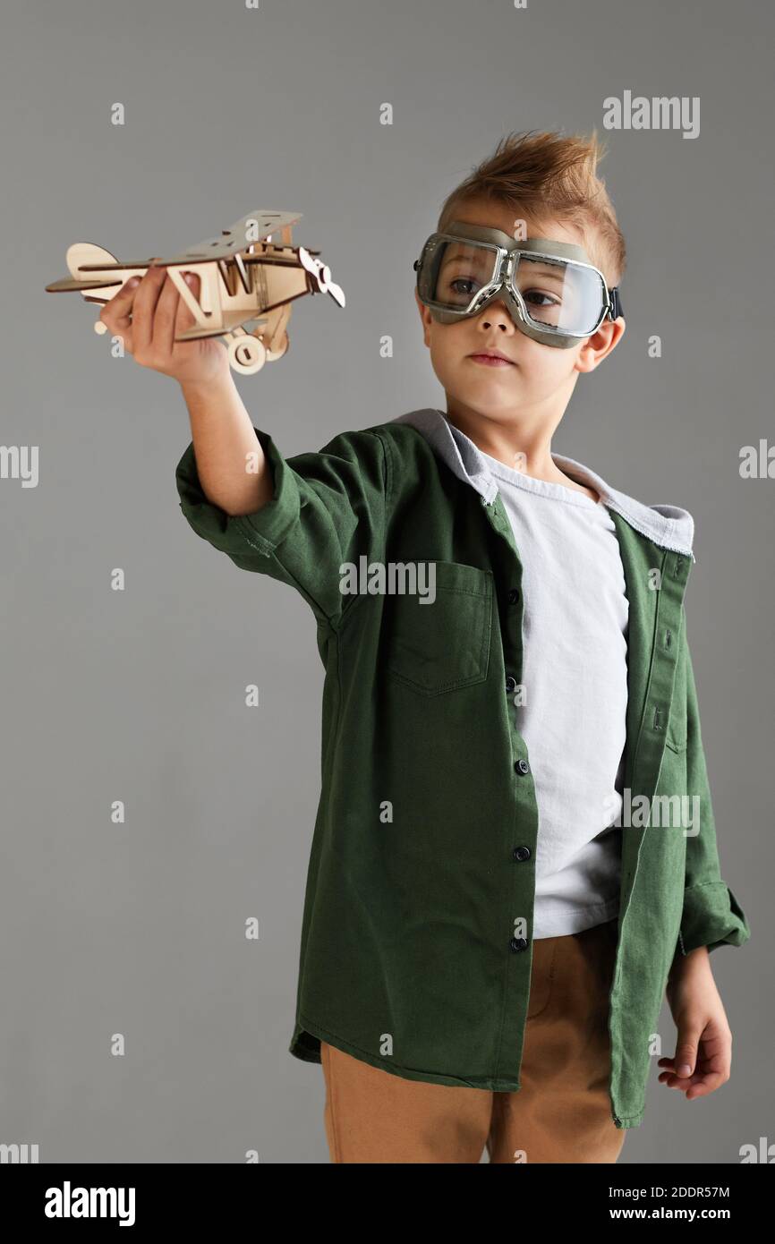 happy child boy in retro glasses playing with wooden toy airplane on ...