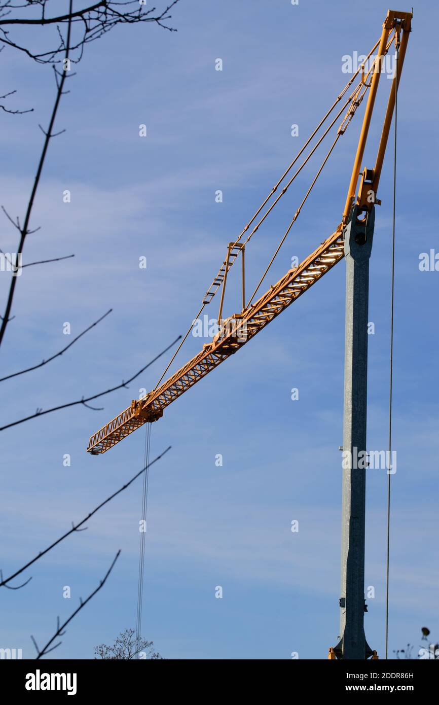 Crane with yellow boom against a blue sky Stock Photo