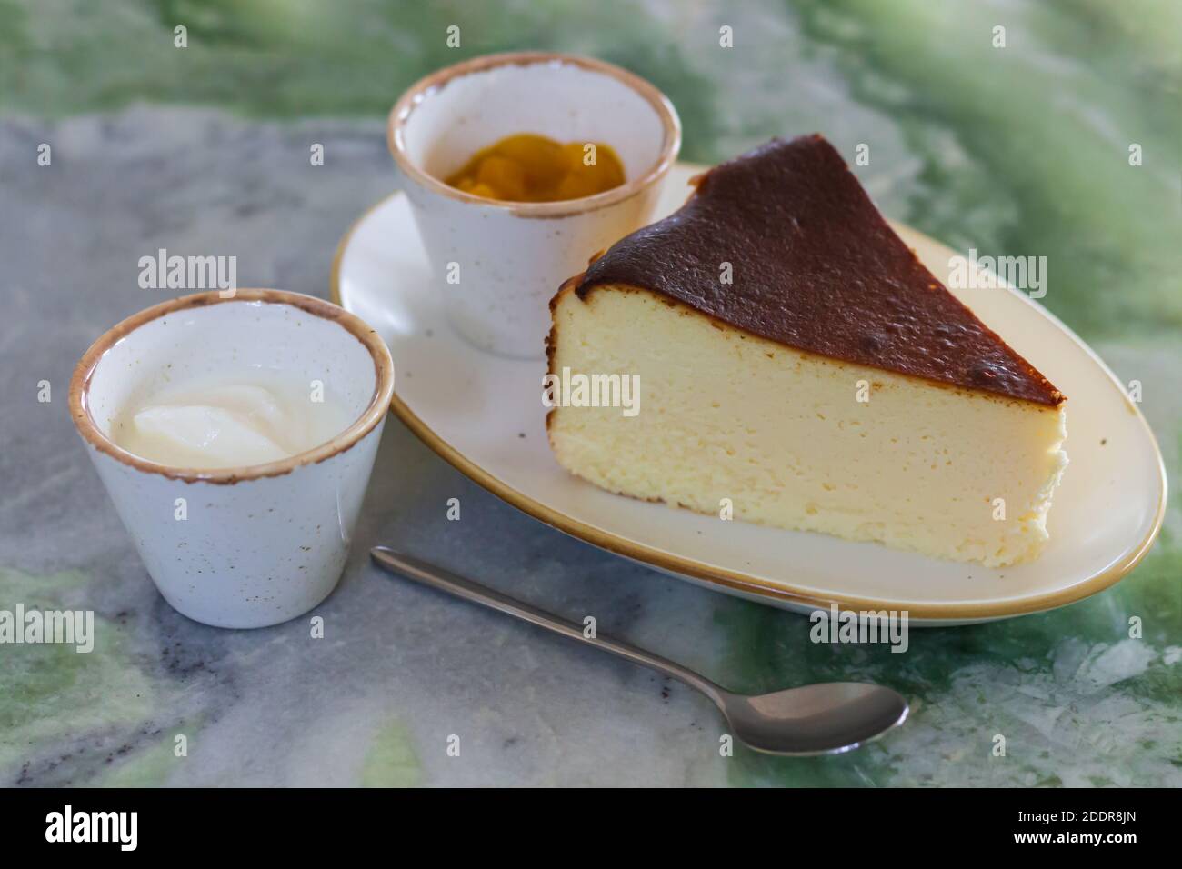 Piece of classic new york cheesecake with sauses on marble table Stock Photo