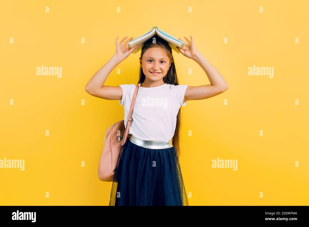 Beautiful smiling teenage girl in school clothes holding books on her ...