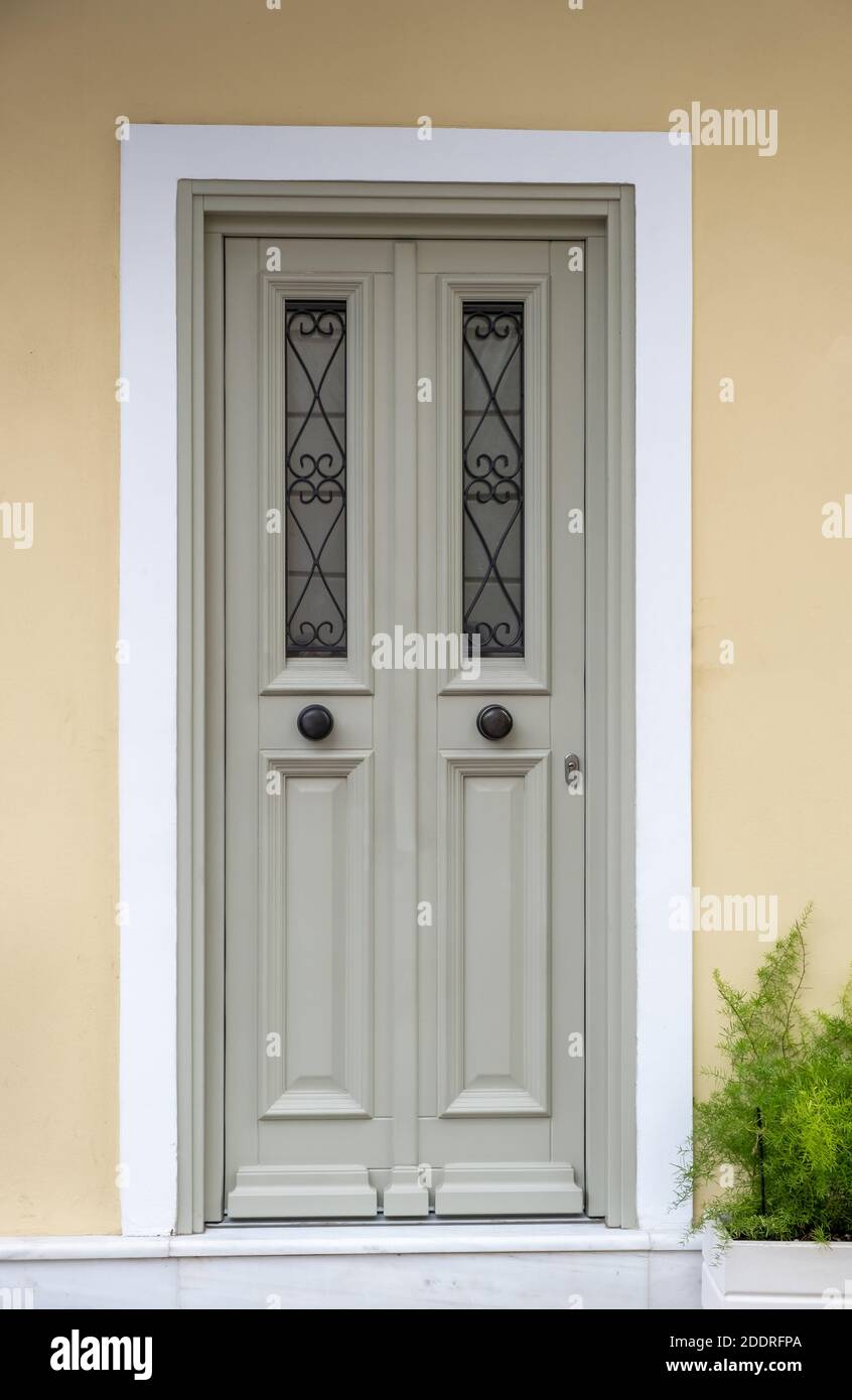 Wooden entrance door, beige yellow color wall background, residential building in old town of Plaka, Athens Greece Stock Photo