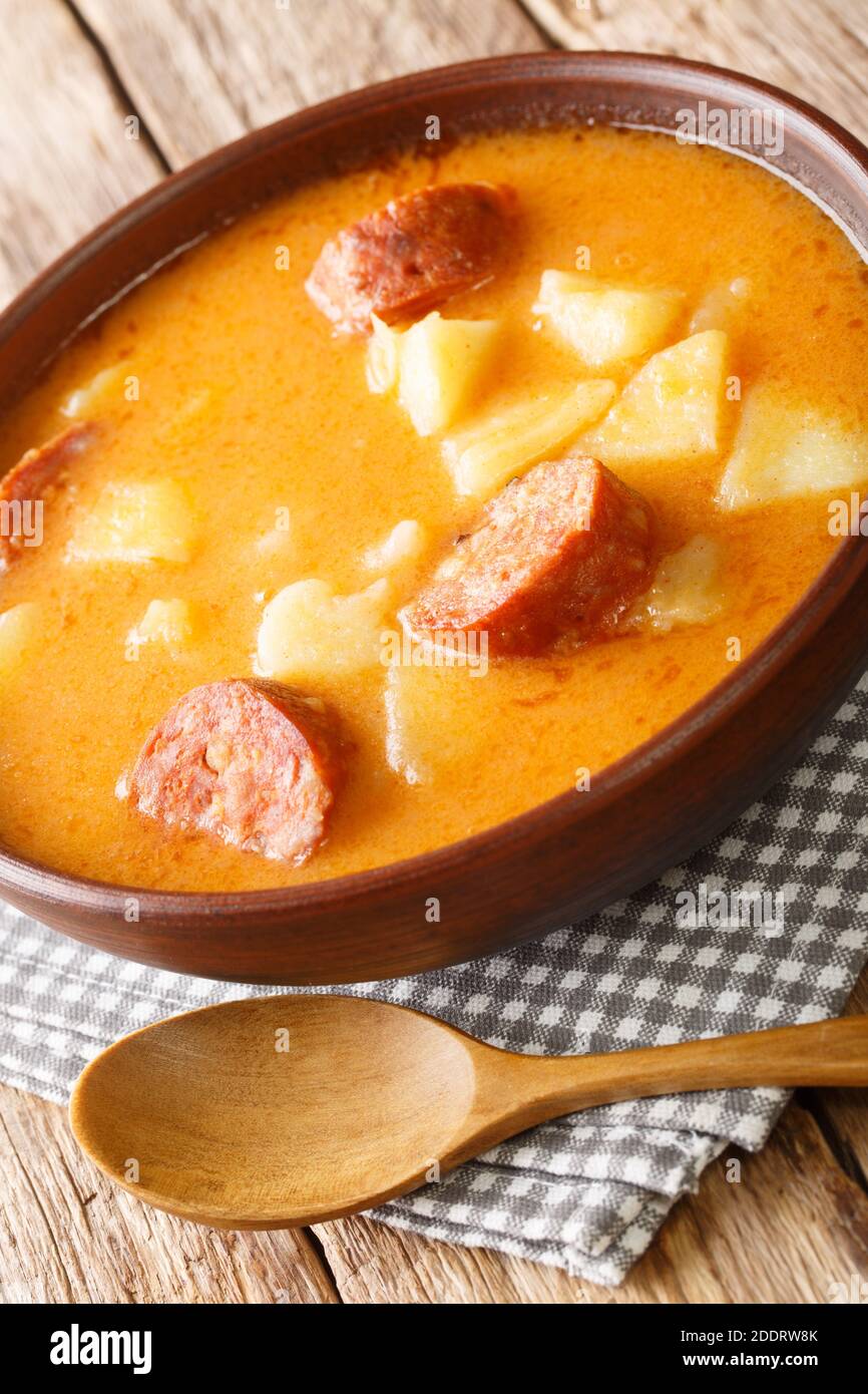 Tasty Hungarian potato soup with sausage and sour cream close-up in a plate on the table. Vertical Stock Photo