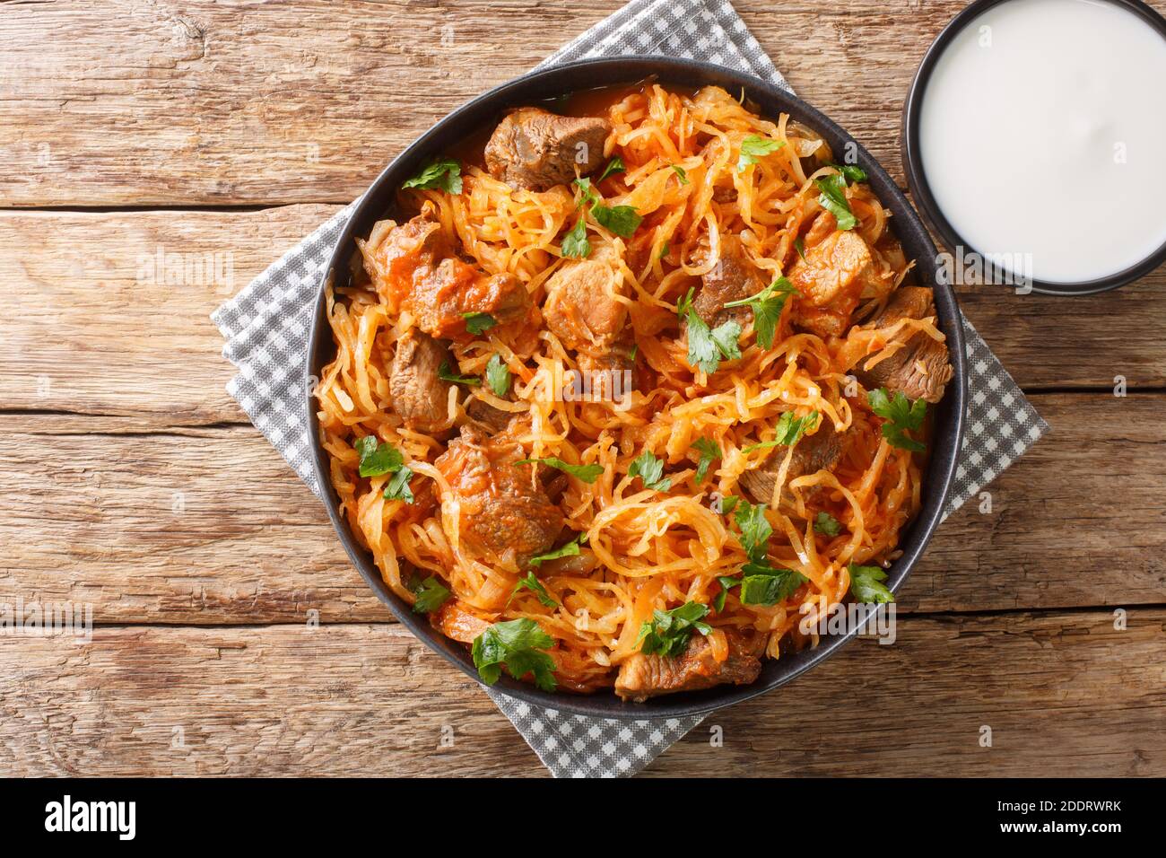Szeged sauerkraut goulash with pork and paprika close-up in a plate on the table. horizontal top view from above Stock Photo