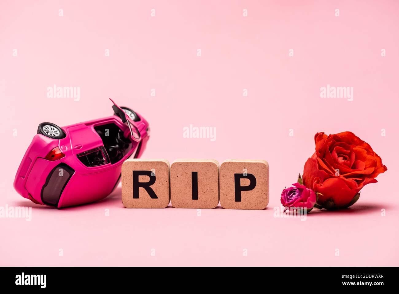 crashed car and word rip with flowers on pink background Stock Photo ...