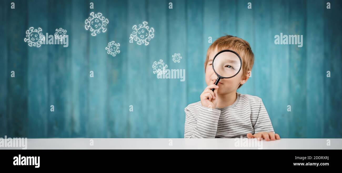 Little boy looking through a magnifying glass Stock Photo