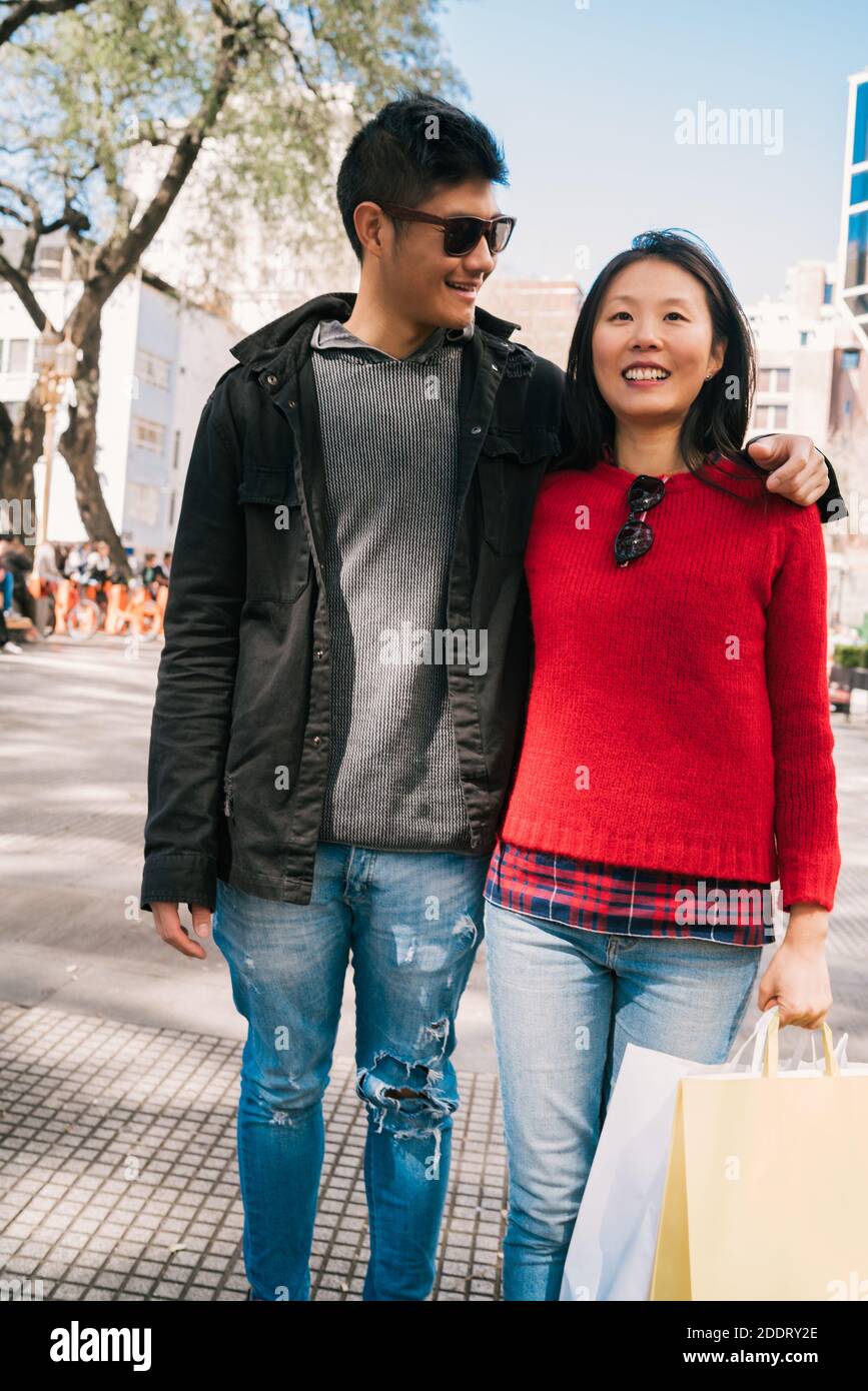 Asian couple walking in the city Stock Photo - Alamy