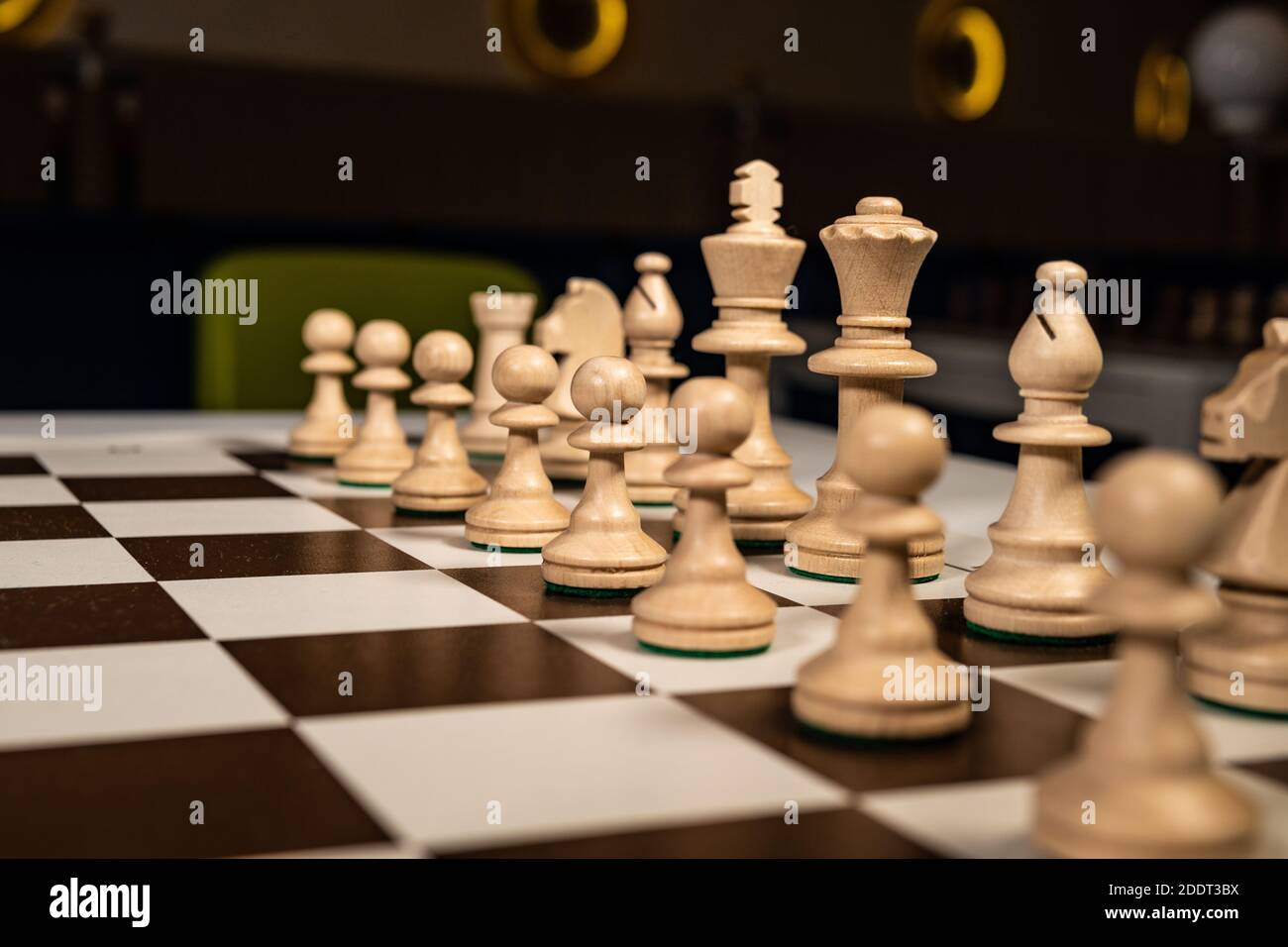 Play a beautiful tree of chess on a platform in a checkered ivory, pawns and rooks, queens and kings, horses table in the dark, stylish for advertisin Stock Photo