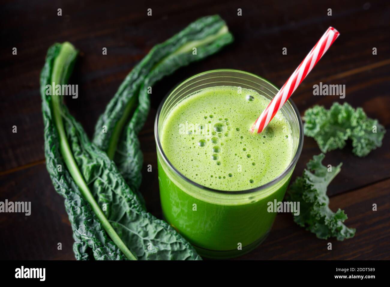 Glass of fresh green juice made with kale on a dark wooden surface Stock Photo