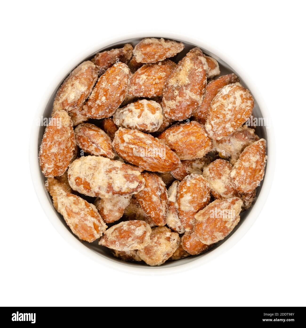 Candied almonds in a white bowl. Homemade, in a special way cooked almonds, whole nuts coated in crunchy sugar. Sold at Christmas markets. Stock Photo