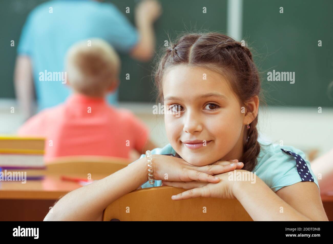Cute smiling schoolgirl at school during lesson Stock Photo - Alamy
