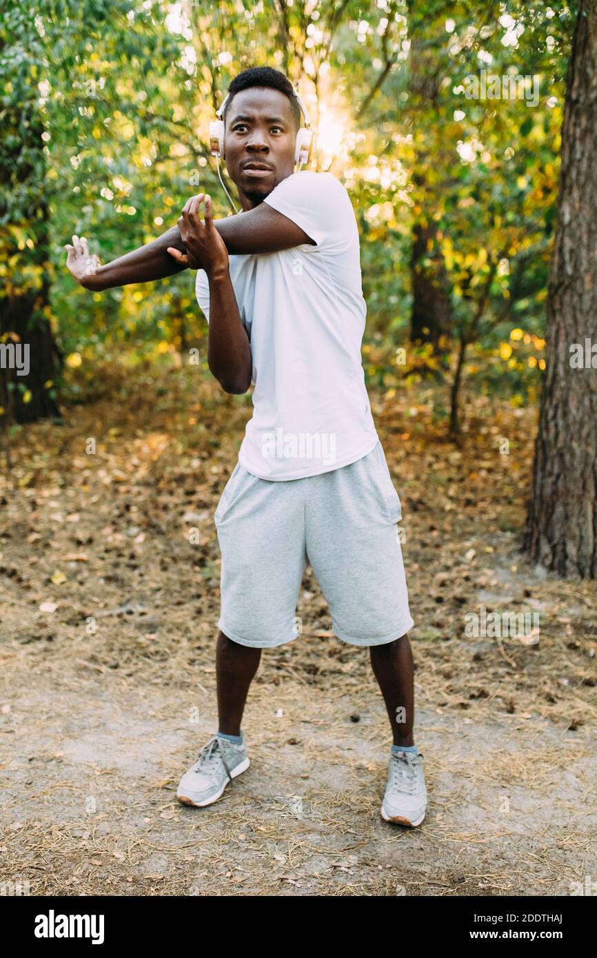 Athletic African American, runner doing stretching exercises, preparing ...