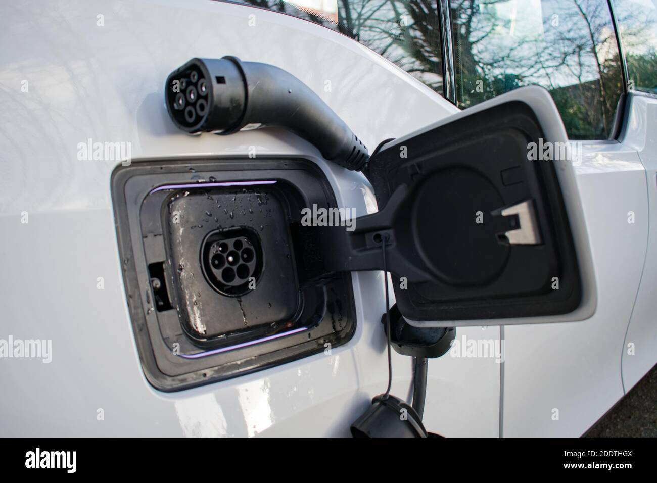 Electric Car Charger At Home Charging EV with lights on Stock Photo