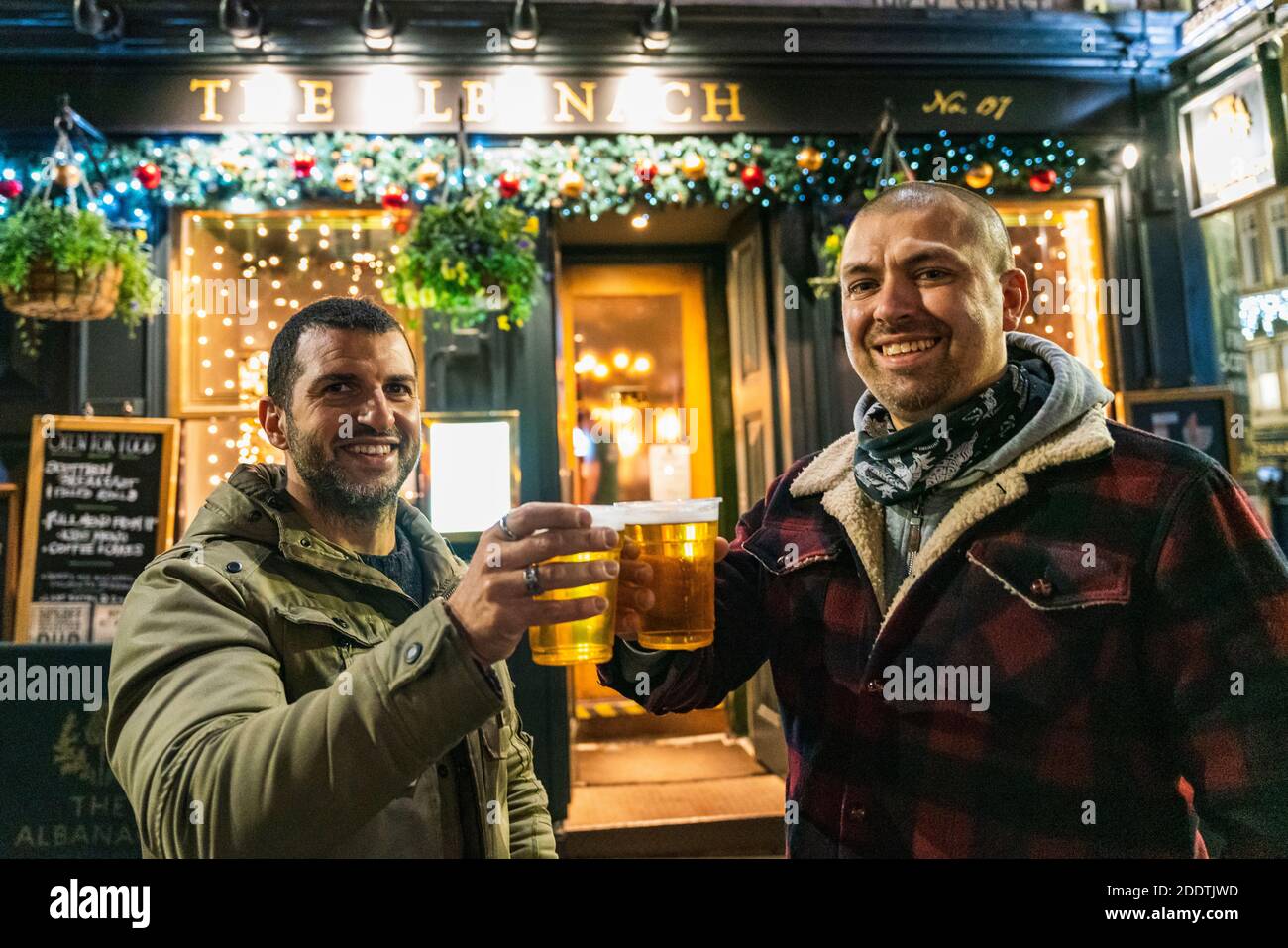 Edinburgh, Scotland, UK. 26 November 2020.Night views of Edinburgh as Christmas approaches.  Pictured; Paolo and Luigi from Italy enjoy a drink outside the Albanach pub on the Royal Mile in EdinburghÕs Old Town.  Credit.  Iain Masterton/Alamy Live News Stock Photo