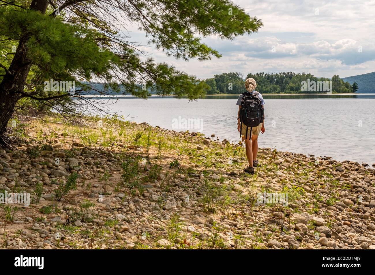 A woman hiking at the waters edge in the Quabbin Reservoir in New Salem, Massachusetts Stock Photo