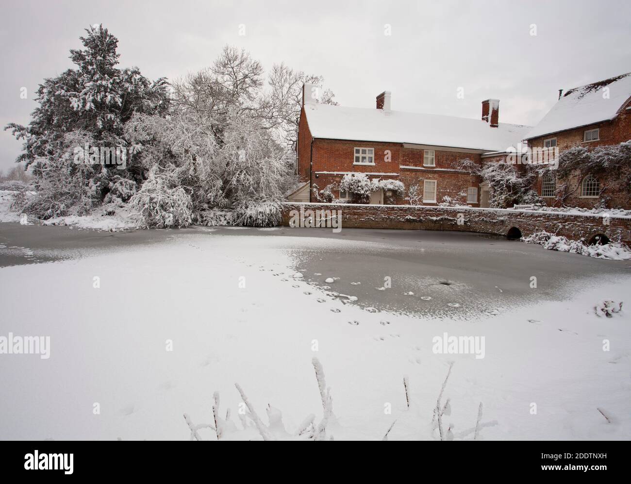 A frozen river stour at Flatford Mill in Suffolk after a heavy winter snowfall Stock Photo