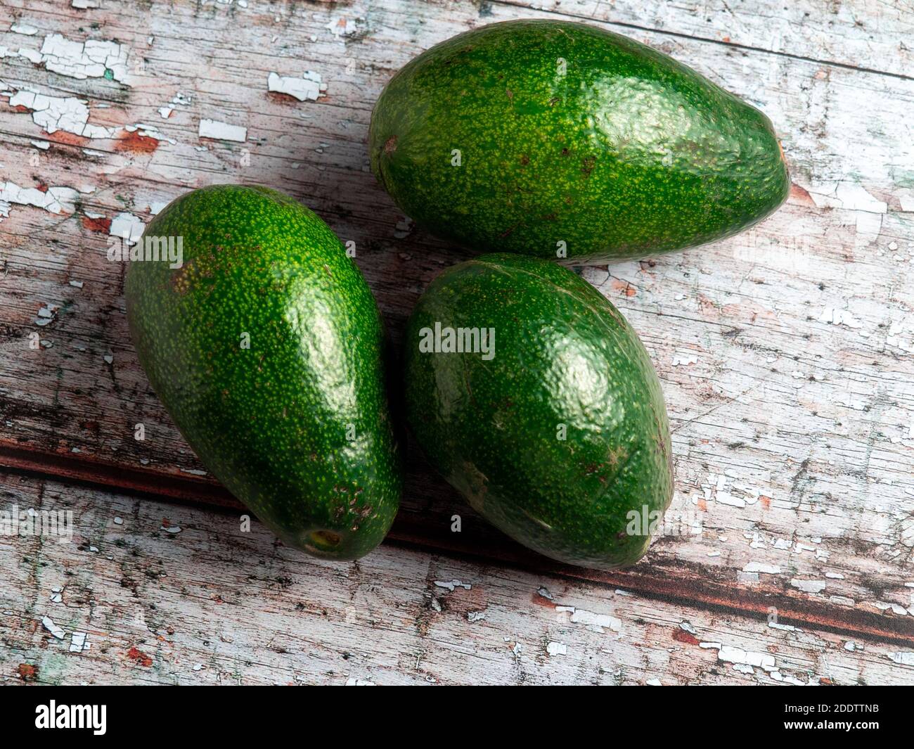 Avocado Stub Ripe A top view of ripe avocados on an old wooden table under the lights ...