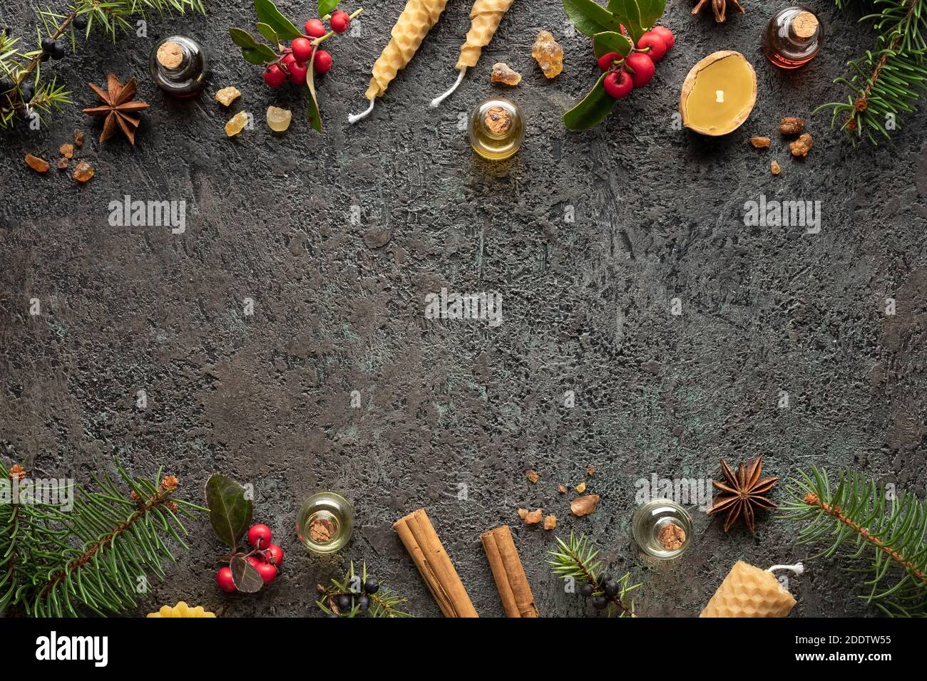 Bottles of essential oil with frankincense, wintergreen, juniper and Christmas spices on a dark background with copy space Stock Photo