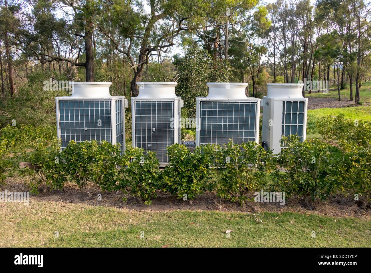 Air conditioner cooling towers outside in a garden surrounded by plants