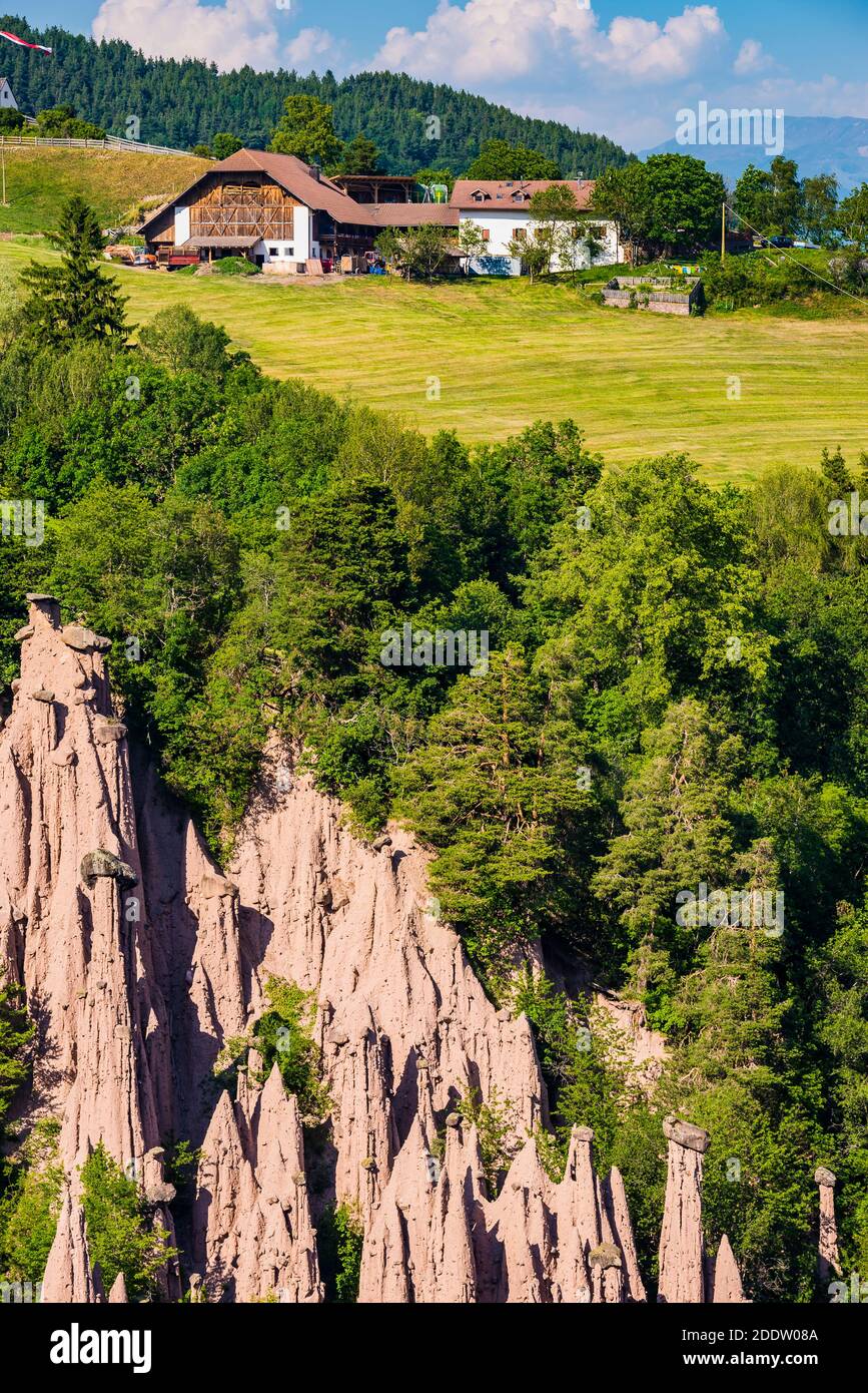 Earth pyramids of Ritten, in the background agricultural and livestock farms. Longomoso, Renon - Ritten region, South Tyrol, Italy, Europe Stock Photo