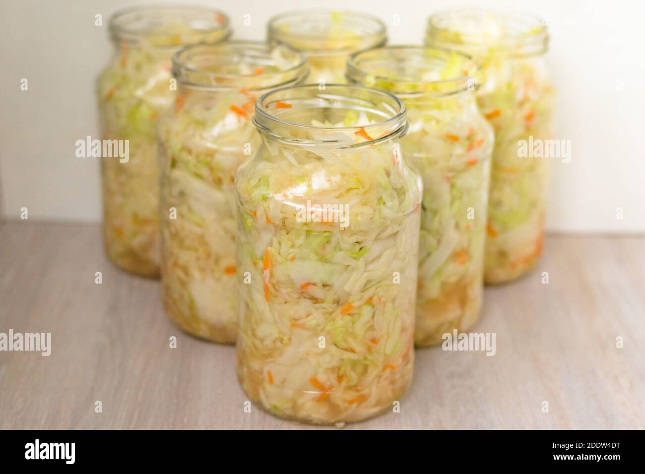 Sauerkraut fermentation in glass jar. Cut white cabbage fermented by