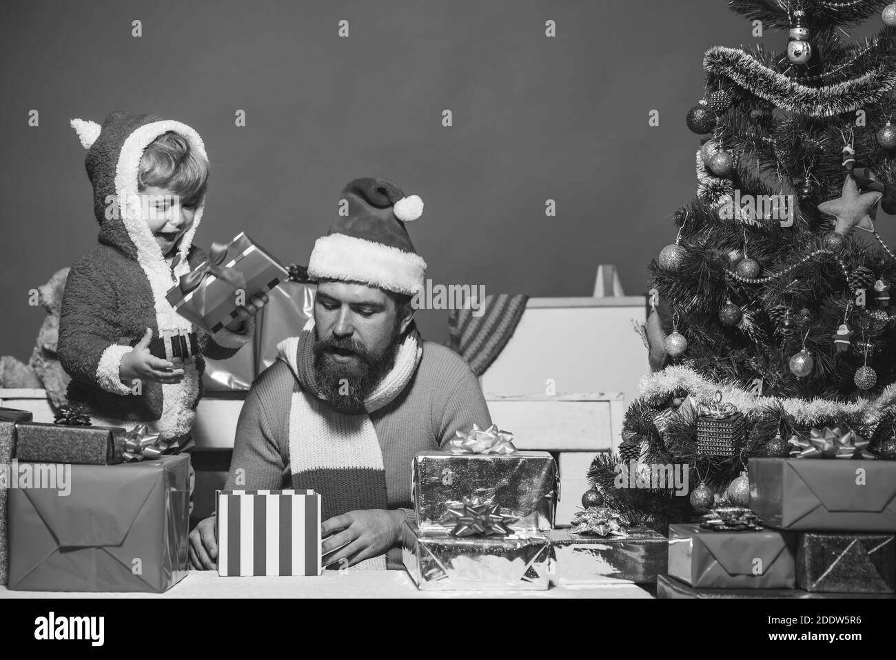 Christmas family opens presents on dark red background. Family holidays