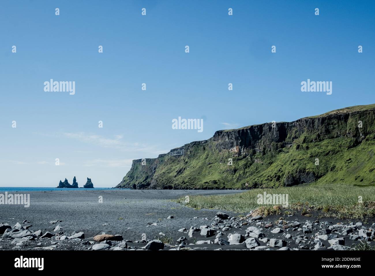 Reynisdrangar rock formations viewed from the town of Vík in South Iceland on a sunny, summer day. Stock Photo