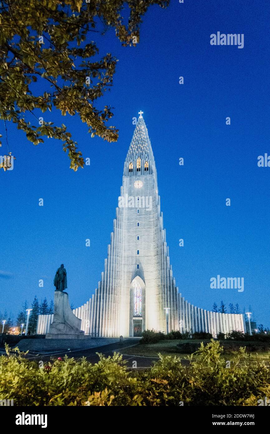 The famous church and tourist attraction Hallgrímskirkja located in downtown Reykjavík, taken at dusk with a clear blue evening sky and lights. Stock Photo