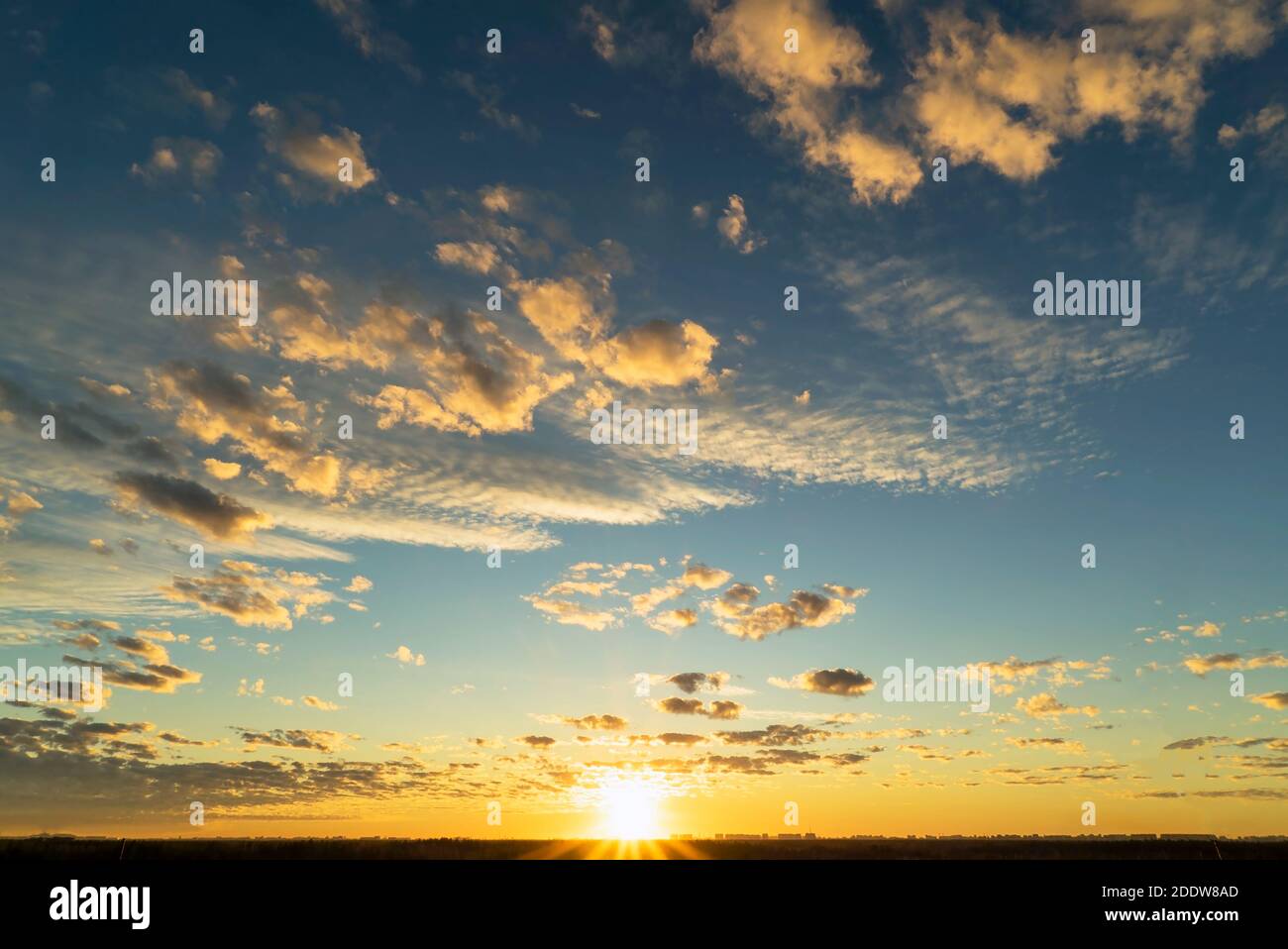 Beautiful Golden clouds illuminated by the rays of the sun at sunset ...