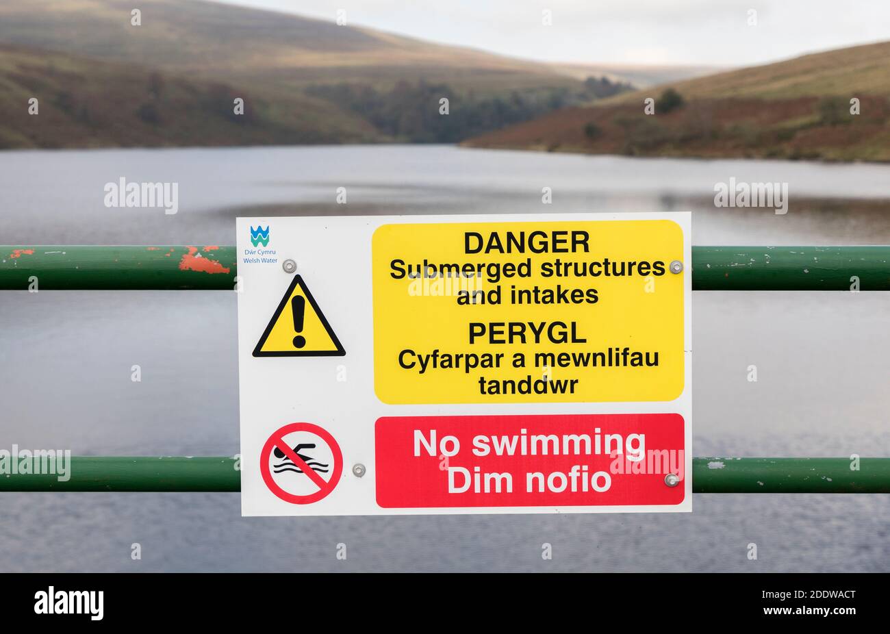 Warning sign of submerged structures in Welsh and English with No Swimming on dam, Grwyne Fawr reservoir, Wales, UK Stock Photo