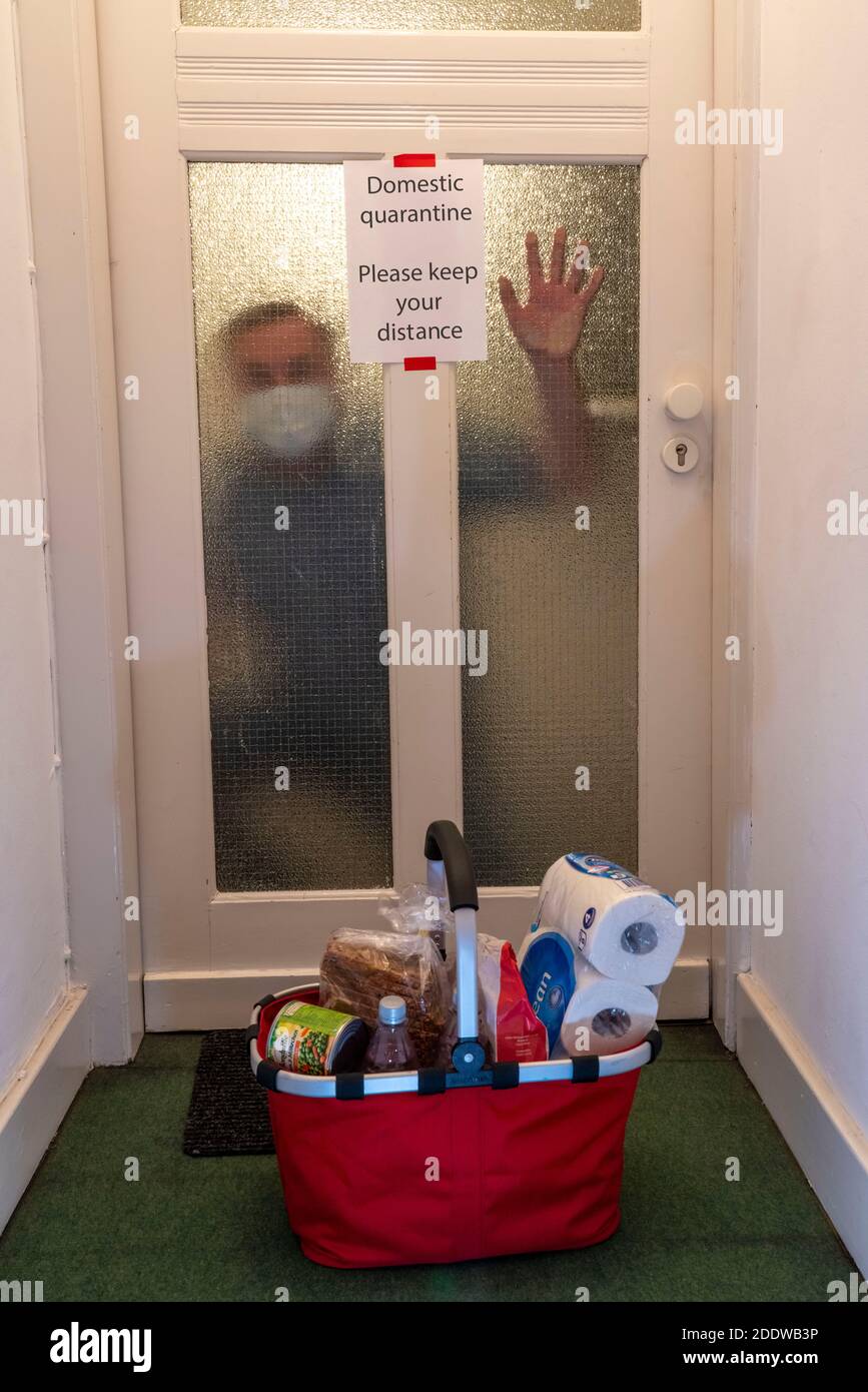 Symbolic image Domestic quarantine, man suspected of corona infection, at home in isolation, warning sign for visitors at the flat door, communicated Stock Photo