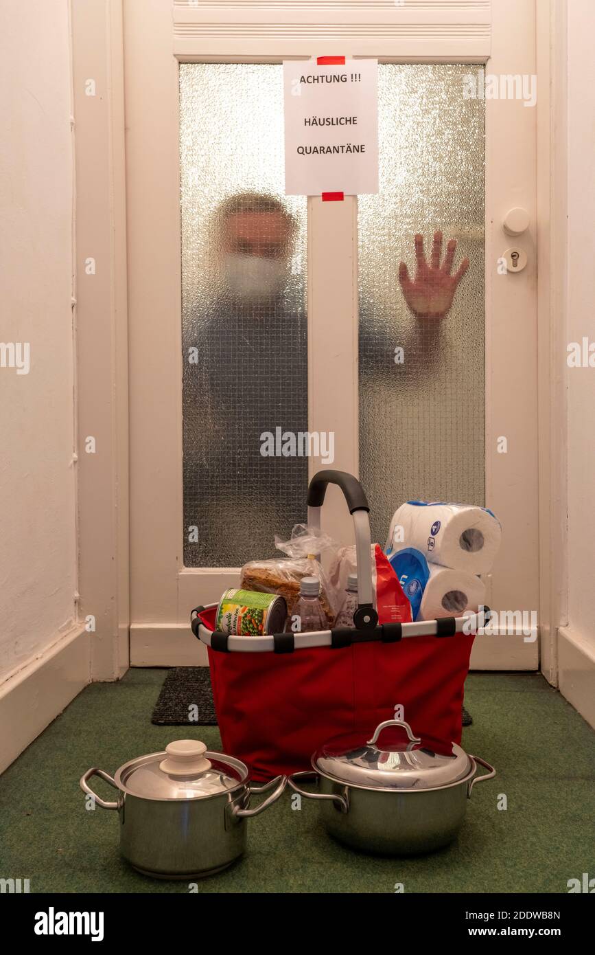 Symbolic image Domestic quarantine, man is suspected of corona infection, at home in isolation, warning sign for visitors at the flat door, communicat Stock Photo