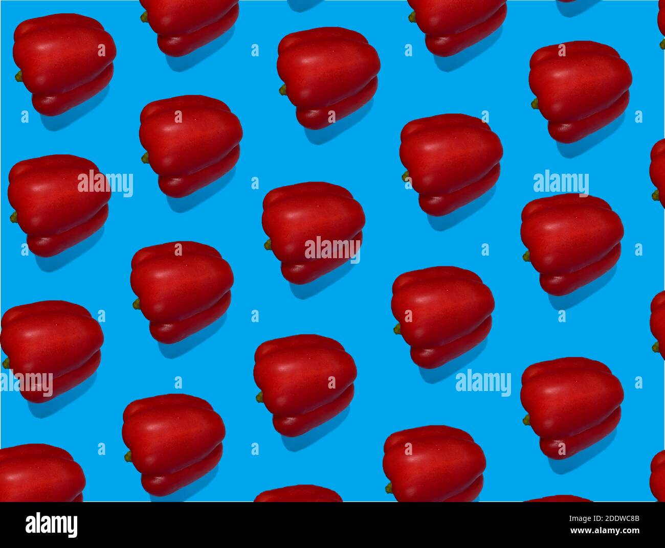 Set of red bell peppers on a blue background. Pattern from red peppers, healthy food concept. Stock Photo