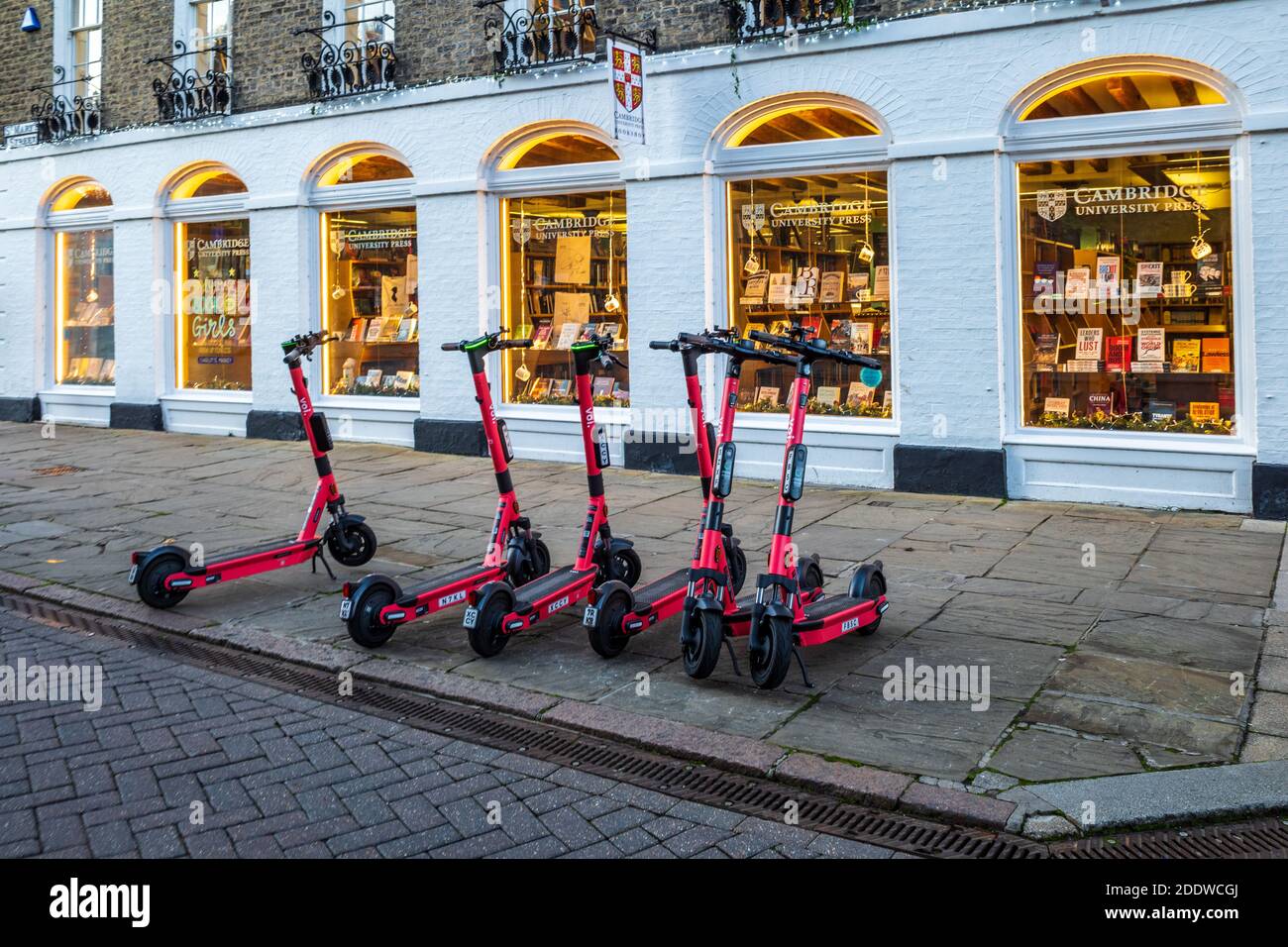 Voi Electric Scooters for hire on a street in the historic centre of Cambridge. Voi Technology e-scooters for hire on a Cambridge street. Stock Photo