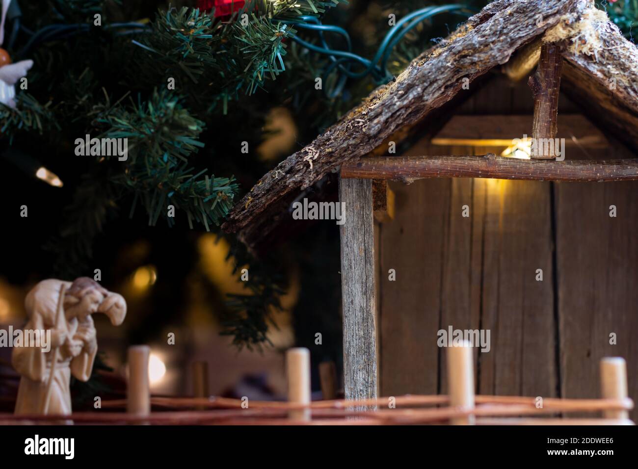 rustic wood nativity scene empty stable waiting under Christmas tree, background Stock Photo