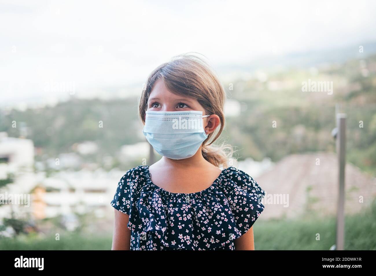 Stock photo of cute girl wearing disposable face mask due to covid19 ...