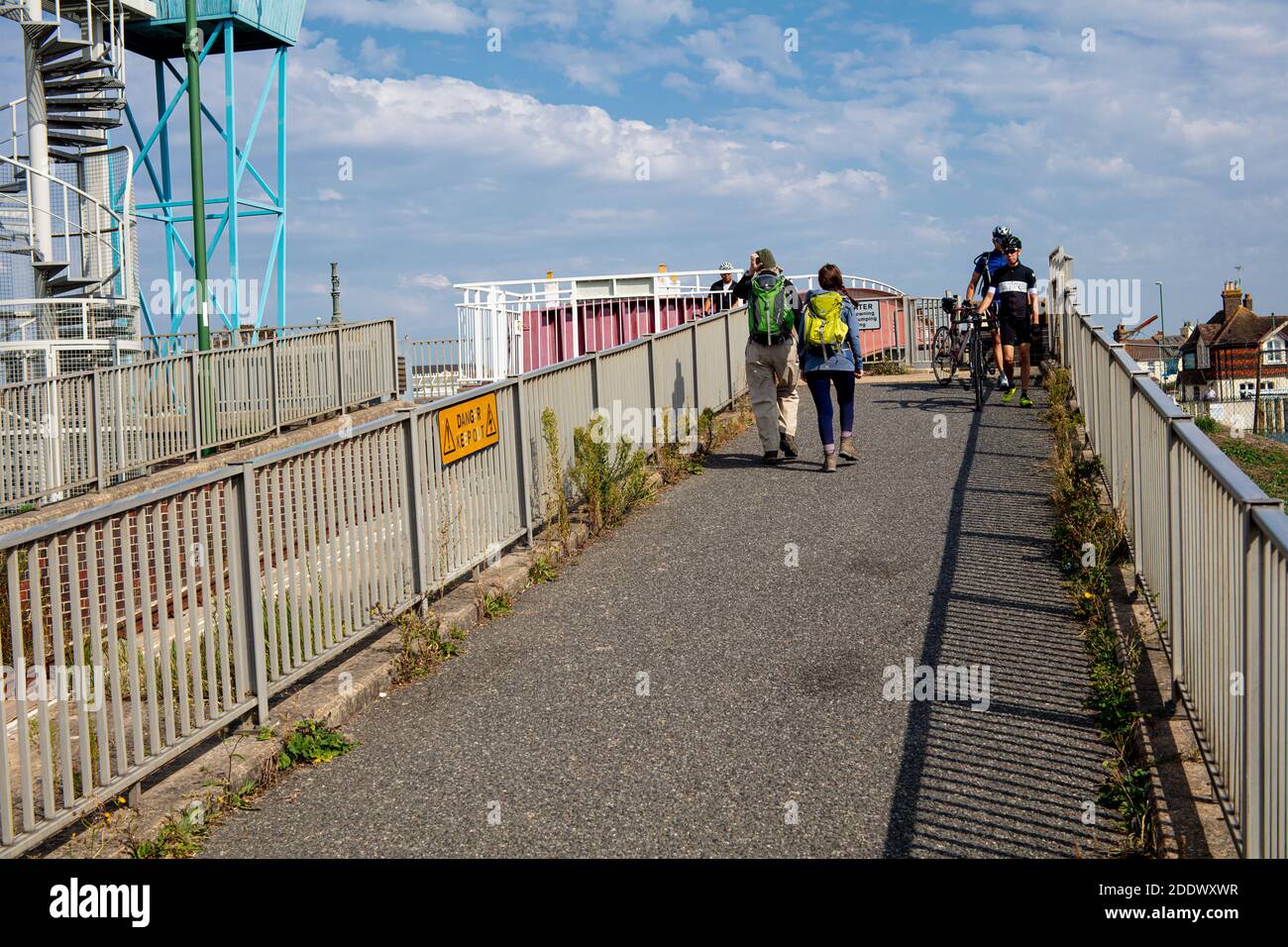 Walkers and cyclists crossing the retractable footbridge over the River Arun, summer, Littlehampton, West Sussex, UK Stock Photo