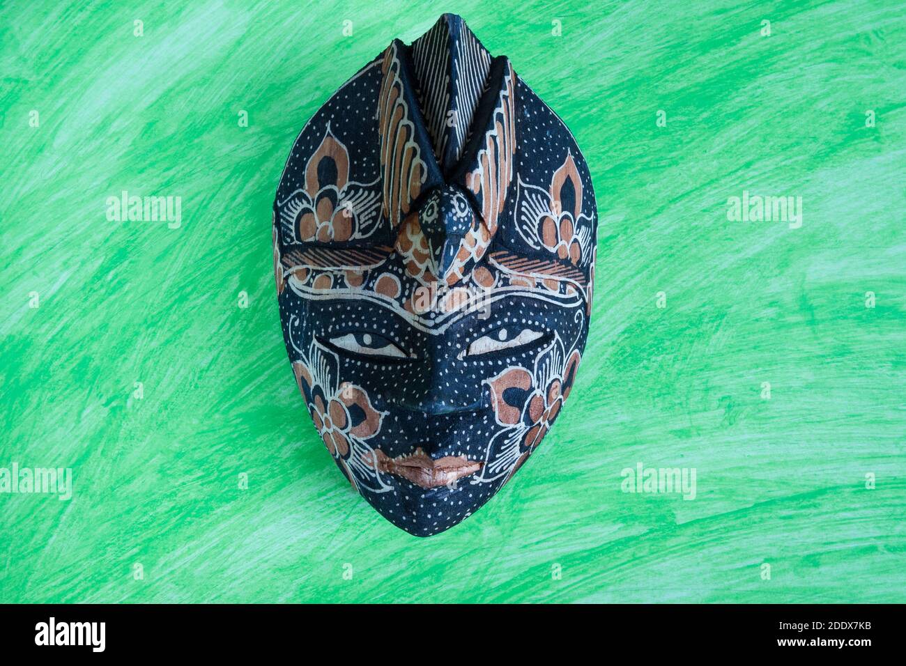 wooden colored african ethnic tribal mask on dark background for wall decoration. Stock Photo