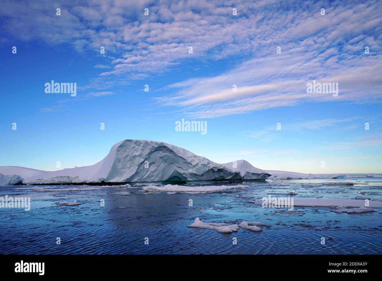 The blue sky shows radial clouds, icebergs and deep blue sea Stock