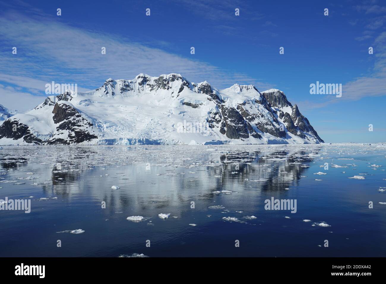 The blue sky shows radial clouds, icebergs and deep blue sea Stock