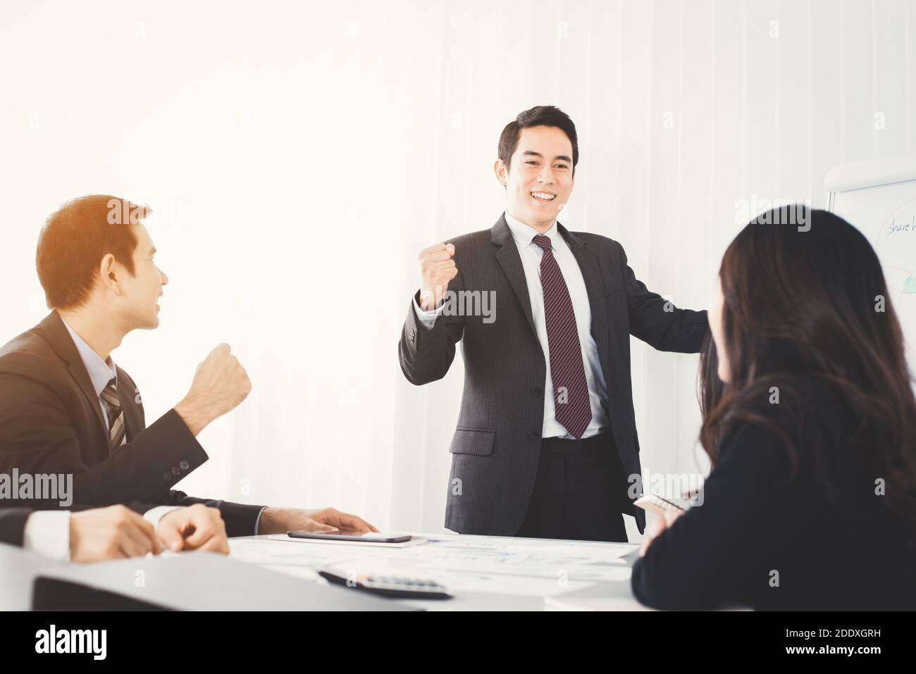 Powerful businessman clenching his fist empowering his colleagues in front of meeting room Stock Photo
