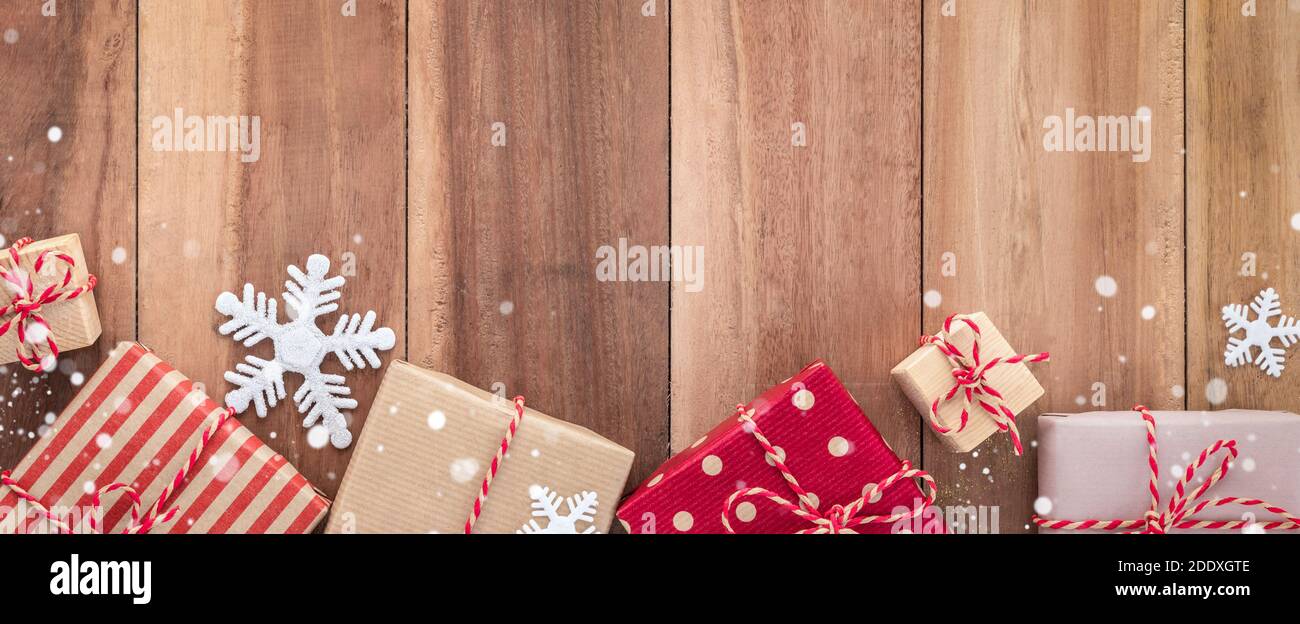 Gift boxes and Christmas ornaments on wood background, border design banner, top view Stock Photo