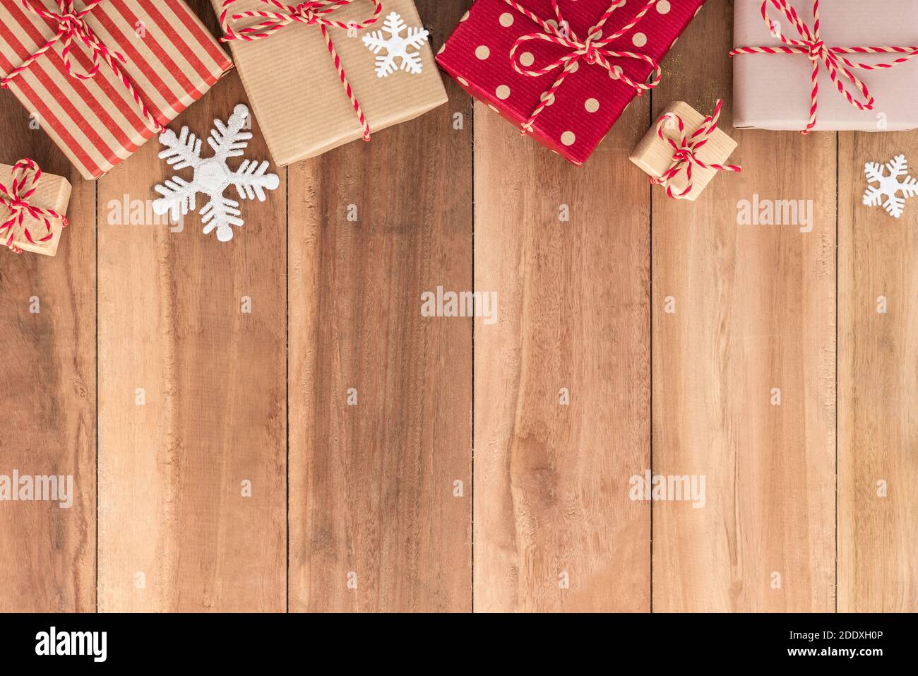 Gift boxes and Christmas ornaments on wood background, border design, top view Stock Photo