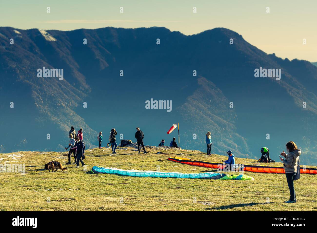 Winter Panorama From The Top Of Monte Avena Clear Skies And Mountain Ranges Paragliders Prepare For Departure Tourists Admire The View Stock Photo Alamy