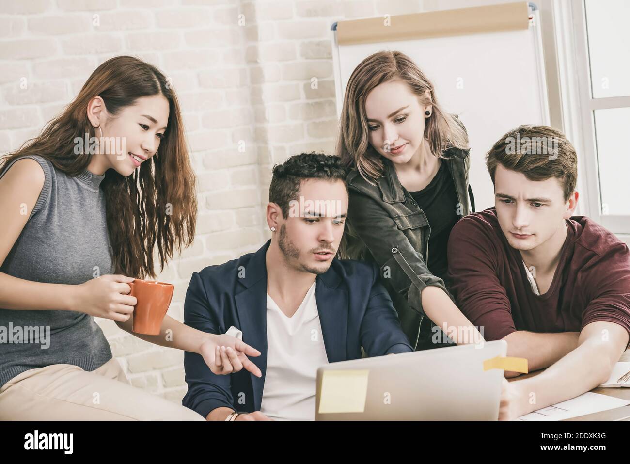 Young casual designer team discussing project group work in office meeting space Stock Photo