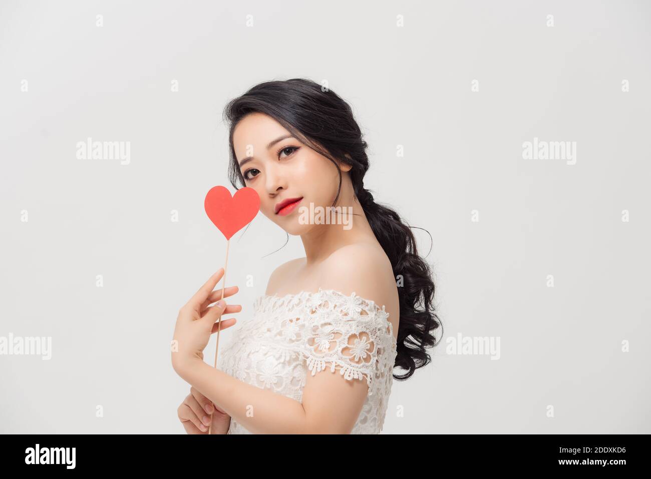 Happy young Asian woman holding love sign over white background Stock ...