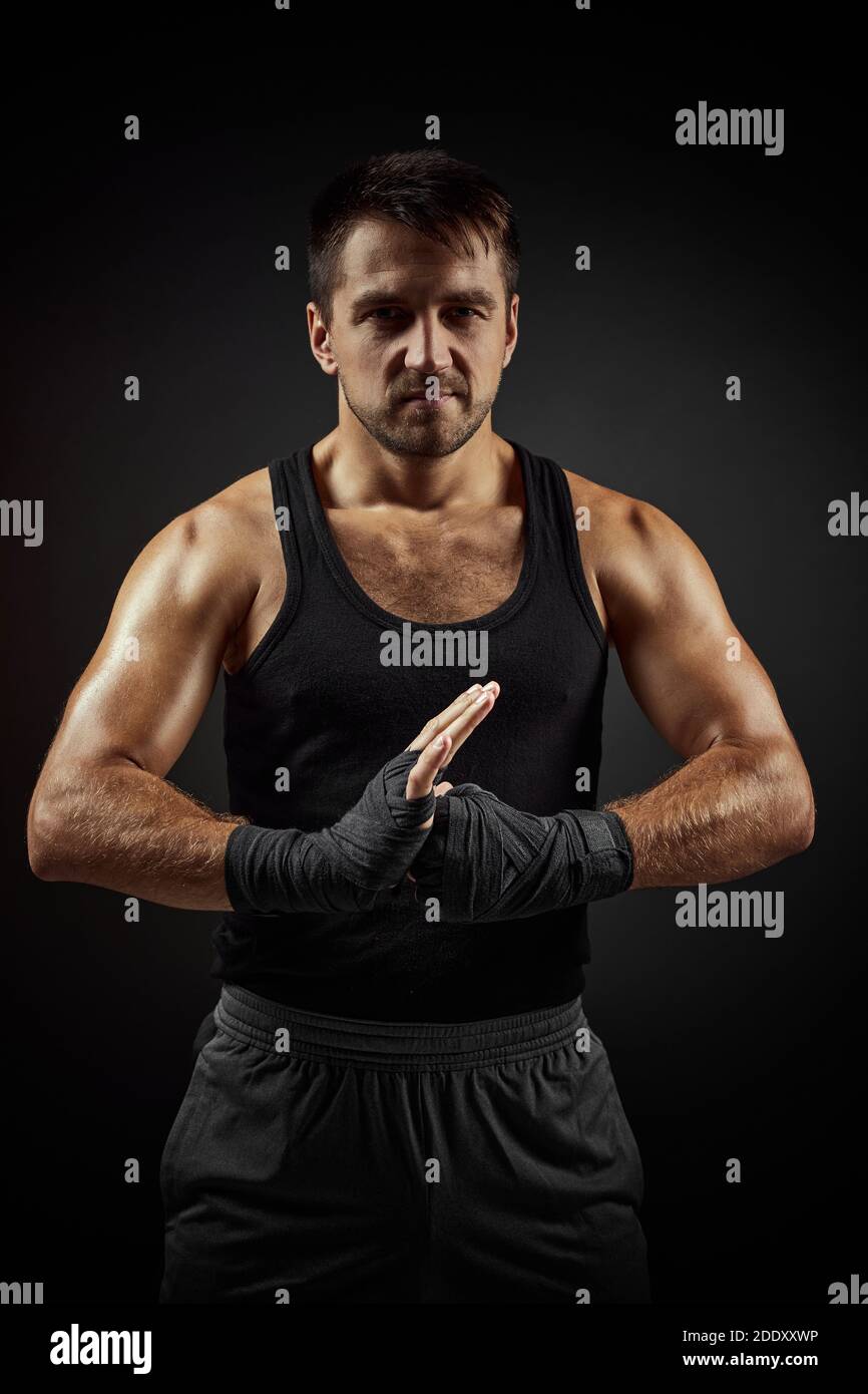 Muscular sporty handsome man in boxing bandage on black backgrround Stock Photo